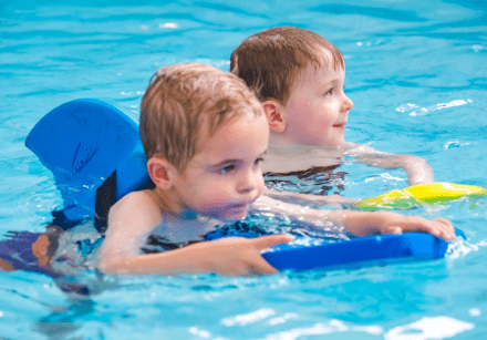 Two pre-school boys learn to swim on their own using floatation aids
