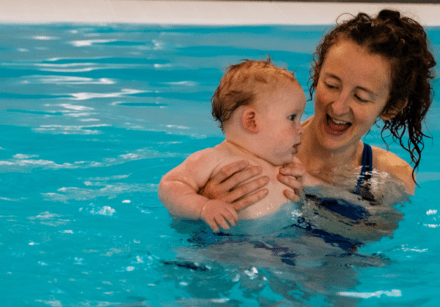A mum and baby enjoy a baby swimming lesson together