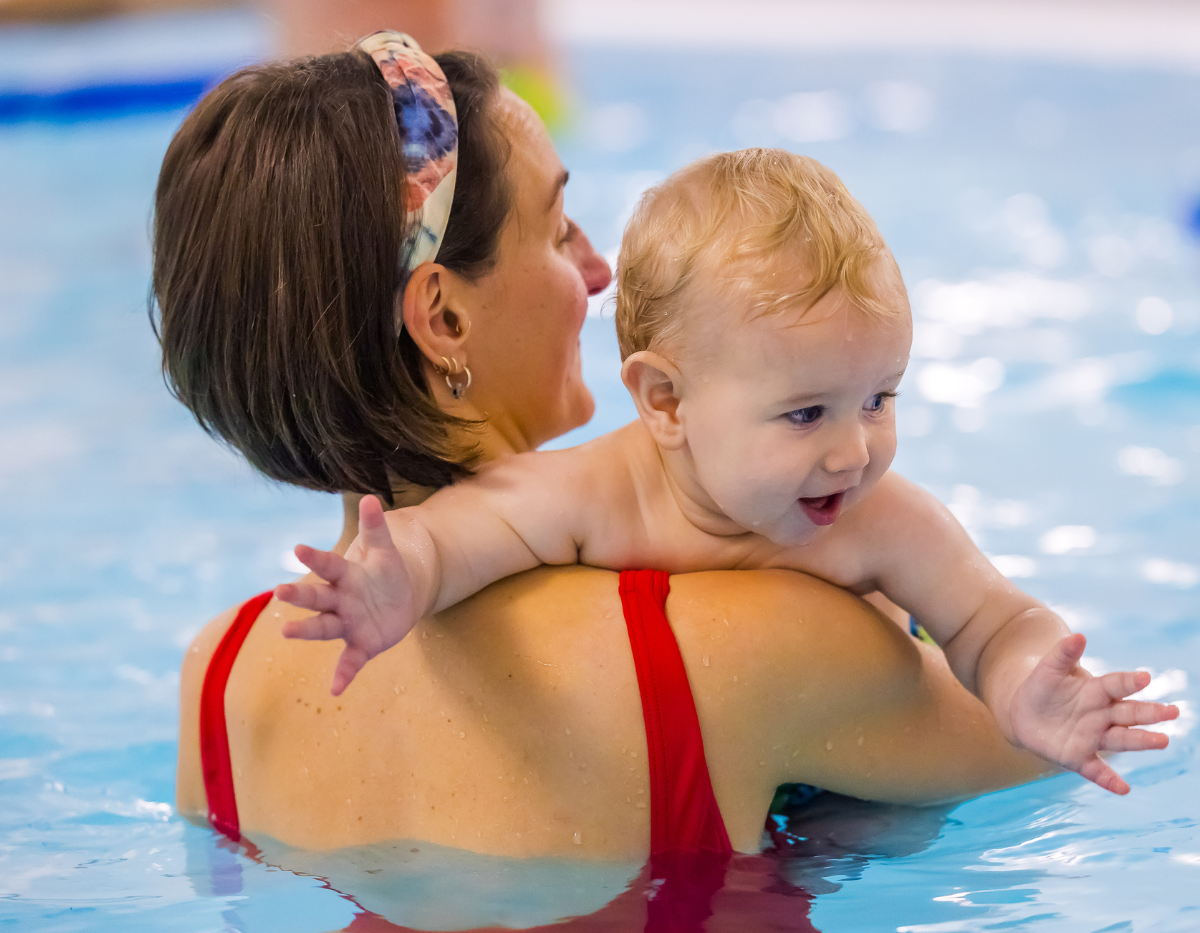 A baby and mum enjoy a cuddle together in the swimming pool