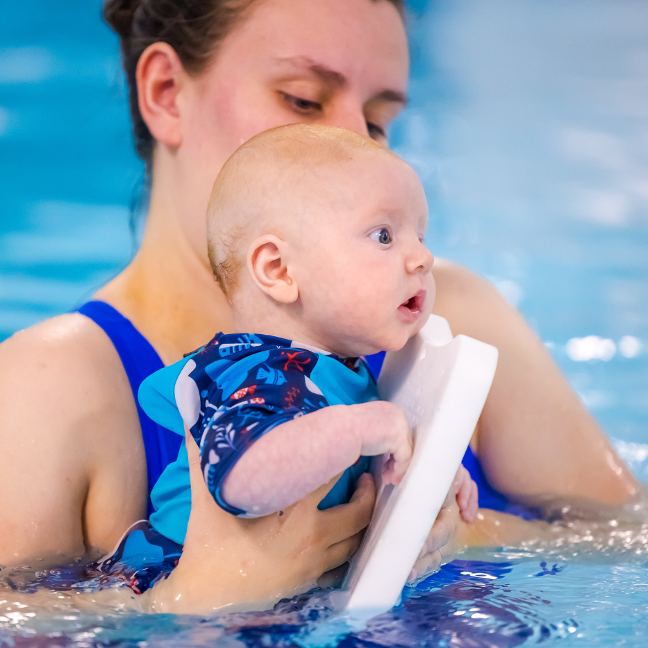 A young baby in the swimming pool with mum